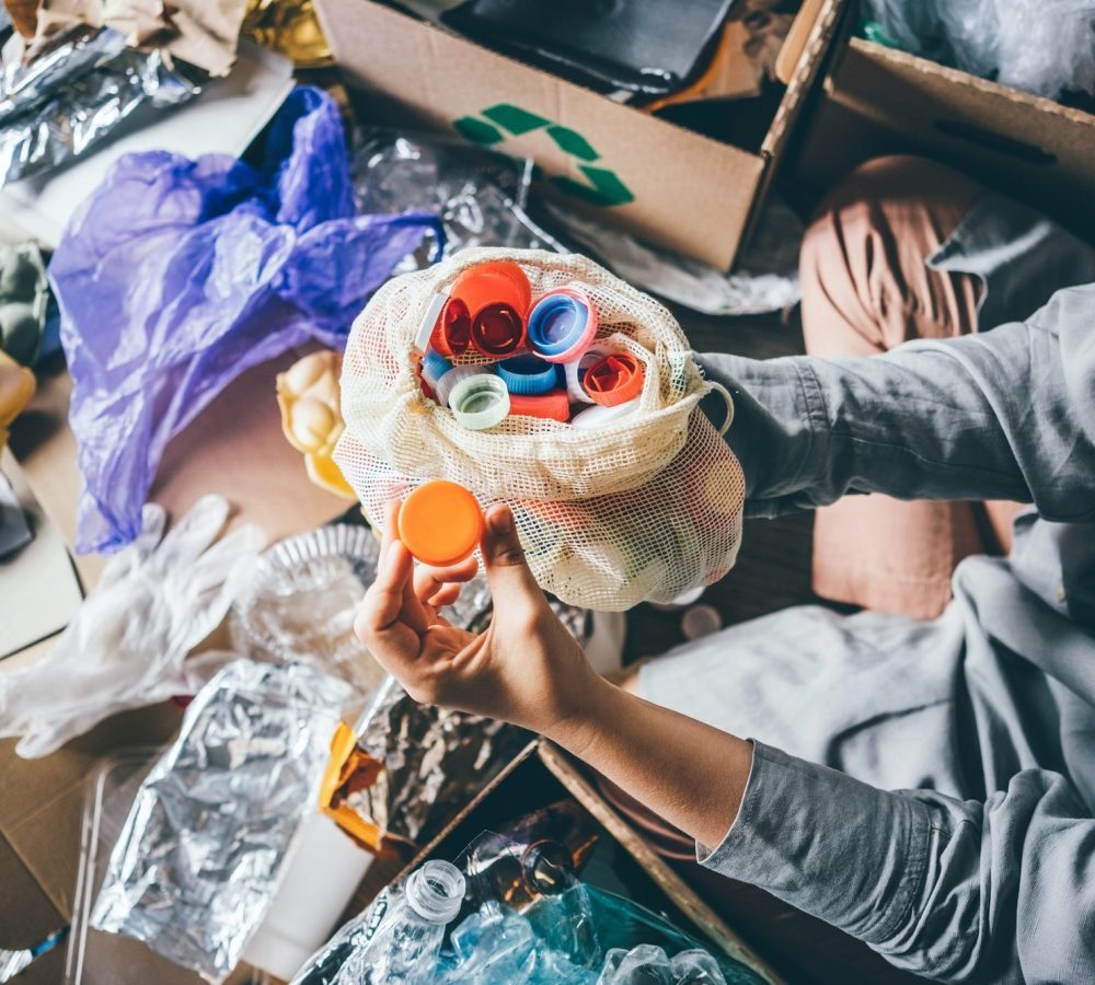 woman-sorting-different-waste-girl-holding-a-plastic-cap-recycling-and-ecology-concept-.jpg